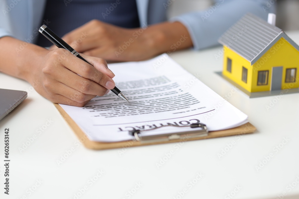 Real estate businessman reading house purchase agreement contract before signing. Real estate businessman reading house purchase agreement contract before signing.