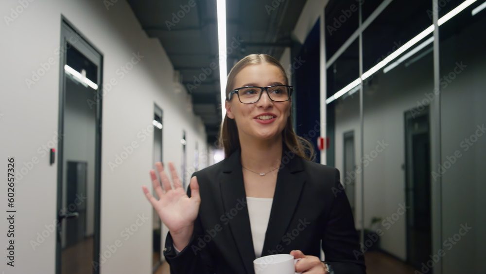 Happy girl walking office corridor morning. Smiling manager holding coffee cup Happy girl walking office corridor morning. Smiling manager holding coffee cup