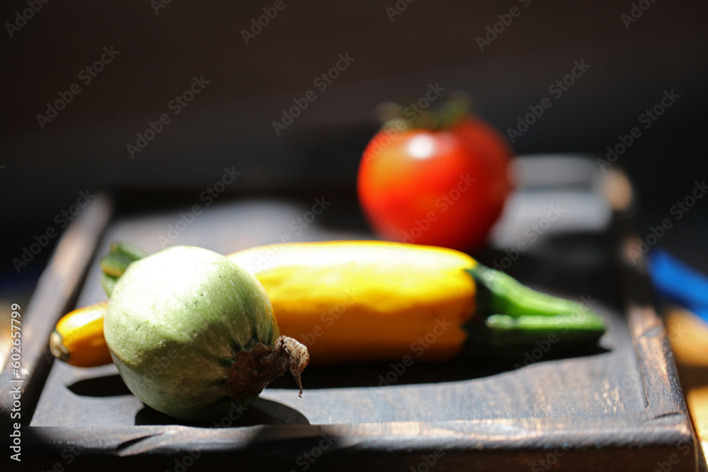 three different vegetables on a wooden plate isolated