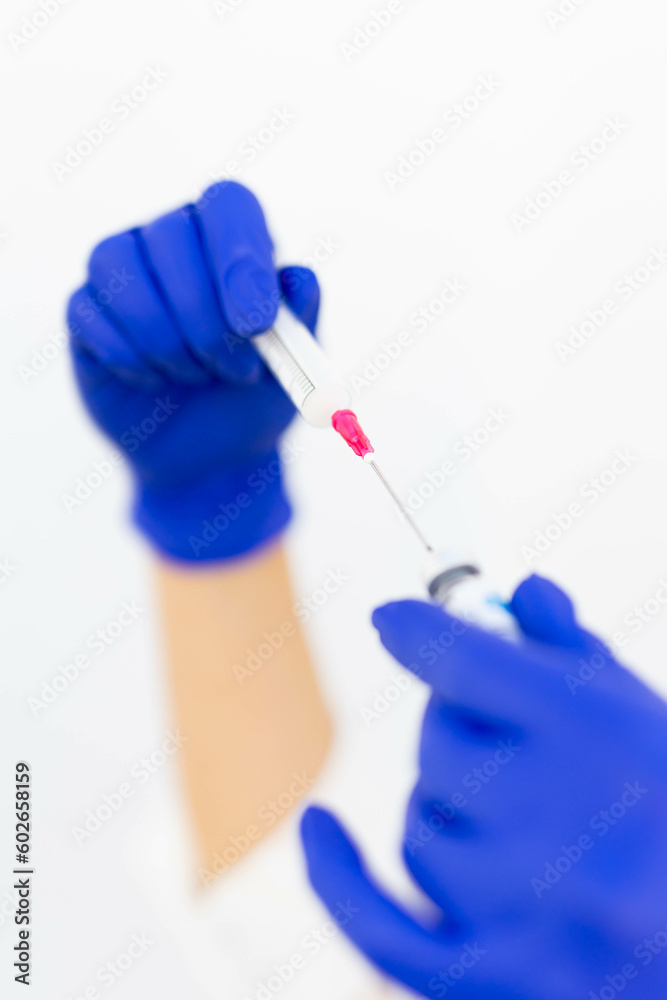 A doctor preparing a vaccine syringe in blue gloves and a mask for a covid 19 vaccination A doctor preparing a vaccine syringe in blue gloves and a mask for a covid 19 vaccination