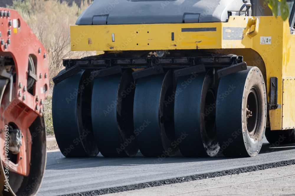 Heavy equipment laying asphalt in a residential neighborhood. Heavy equipment laying asphalt in a residential neighborhood.
