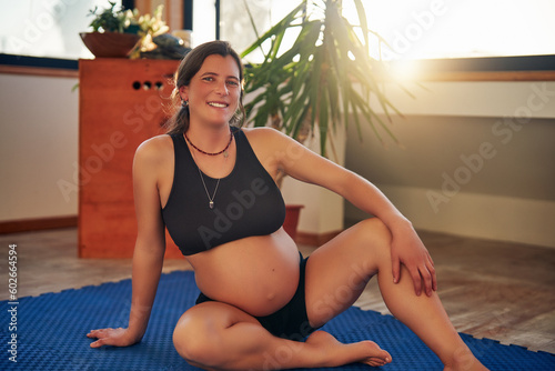 portrait sitting pregnant caucasian woman indoors in yoga studio