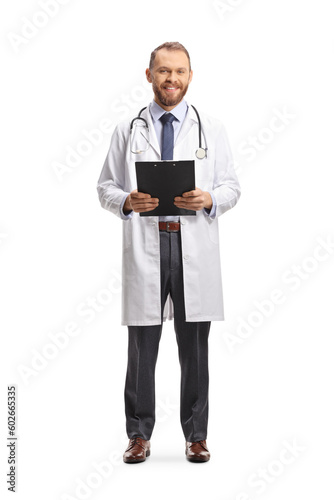 Full length portrait of a male physician smiling and holding a clipboard