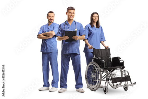 Medical workers in blue uniforms standing with a wheelchair