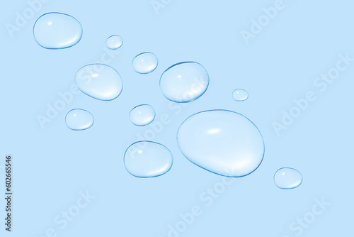 Drops of transparent gel or water in different sizes. On a blue background.