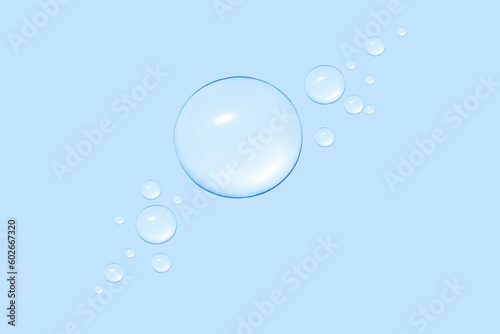 Drops of transparent gel or water in different sizes. On a blue background.