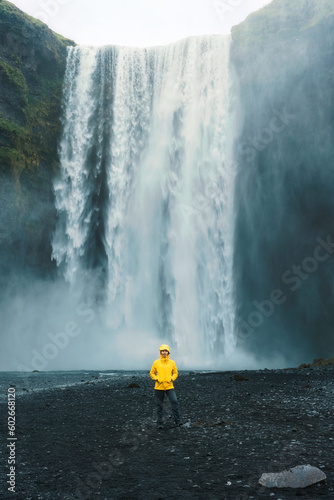Skogafoss waterfall flowing with asian woman standing in summer at Iceland