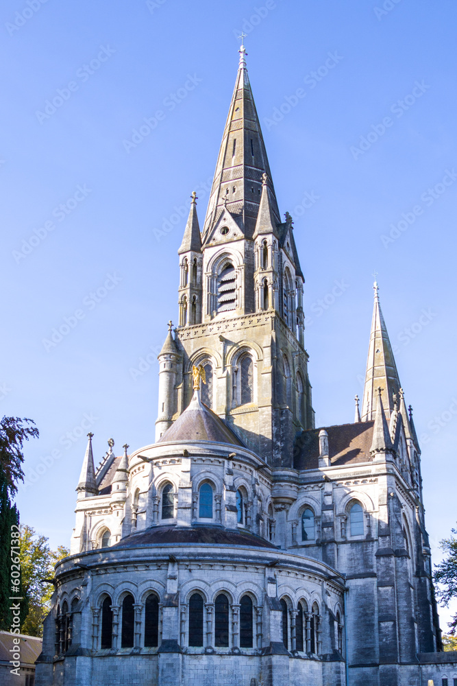 The tall Gothic spire of an Anglican church in Cork, Ireland. Neo-Gothic Christian religious architecture. Cathedral Church of St Fin Barre, Cork - One of Ireland’s Iconic Buildings.