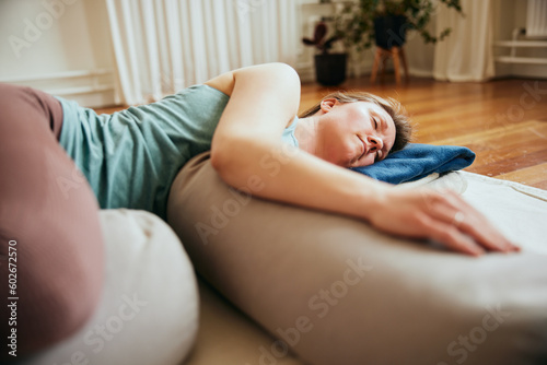 Woman doing restorative yoga using bolsters photo