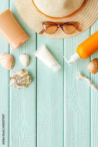 Summer vacation beach flatlay with sunprotection cosmetic and straw hat photo