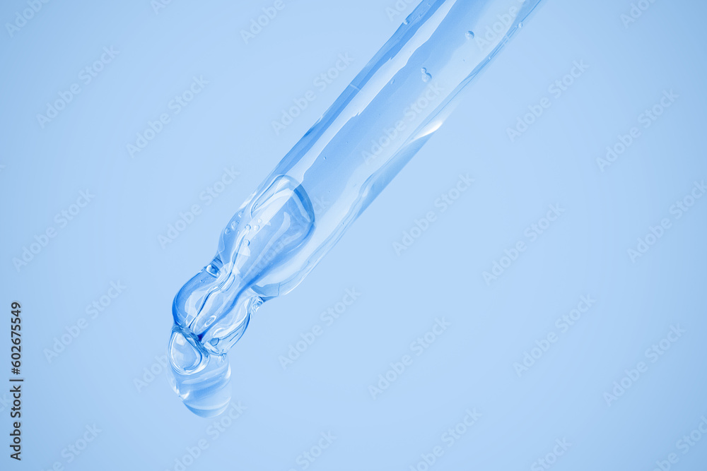 Transparent cosmetic gel flows from the dropper. On a blue background. Hyaluronic acid, toner, toner, gel, cream. Cosmetics. Transparent cosmetic gel flows from the dropper. On a blue background. Hyaluronic acid, toner, toner, gel, cream. Cosmetics.