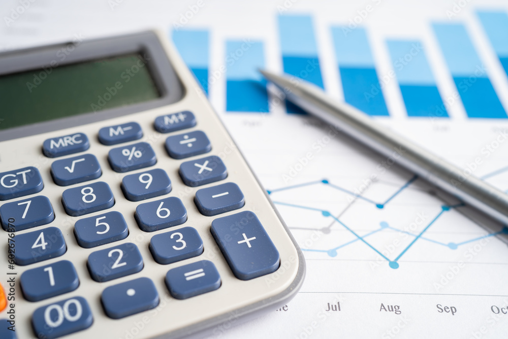 Pen and calculator on chart or graph paper. Financial, account, statistics and business data concept. Pen and calculator on chart or graph paper. Financial, account, statistics and business data concept.