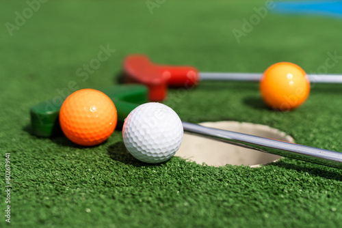 Close-up of miniature golf hole with bat and ball