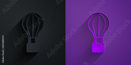 Paper cut Hot air balloon icon isolated on black on purple background. Air transport for travel. Paper art style. Vector