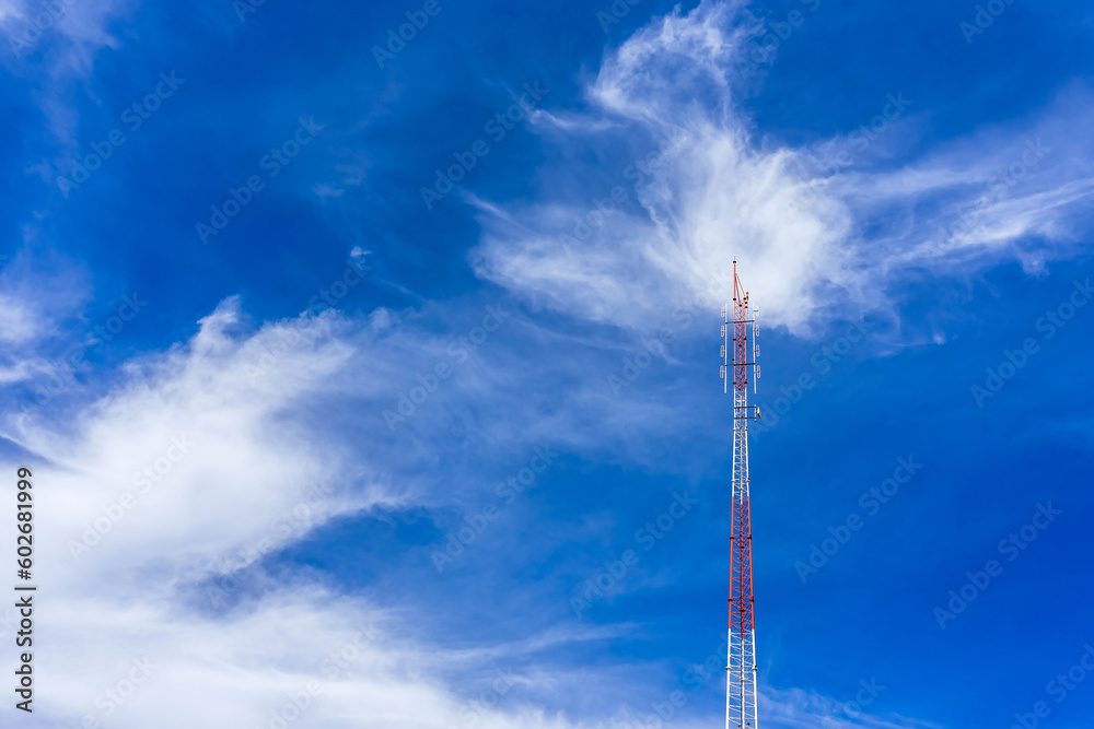 Telecommunication radio wave signal tower red and white with cloudy. Steel truss of transmission signal antenna with blue sky. Telecommunication tower, Global connection and internet network concept. Telecommunication radio wave signal tower red and white with cloudy. Steel truss of transmission signal antenna with blue sky. Telecommunication tower, Global connection and internet network concept.