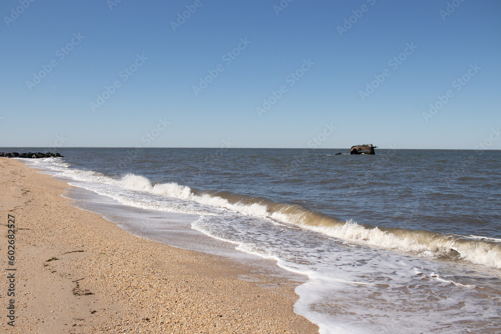 I love the look of this beach image wit the surf pounding the sand. The whitecaps of the waves gives it a rough look. The sand is filled with pebbles and debris of what washed up.