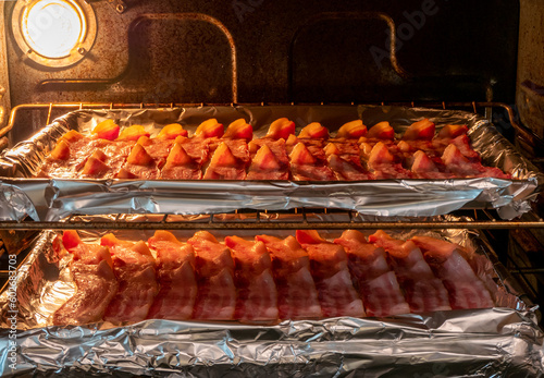 Racks of bacon cooking in an oven 