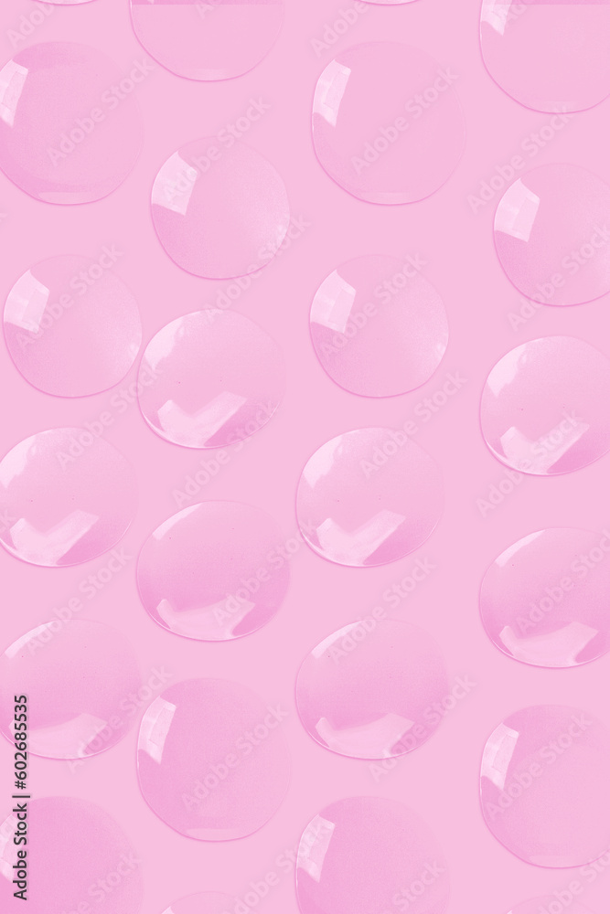 round drops of transparent gel serum on a pink background. gel with bubbles. Water droplets