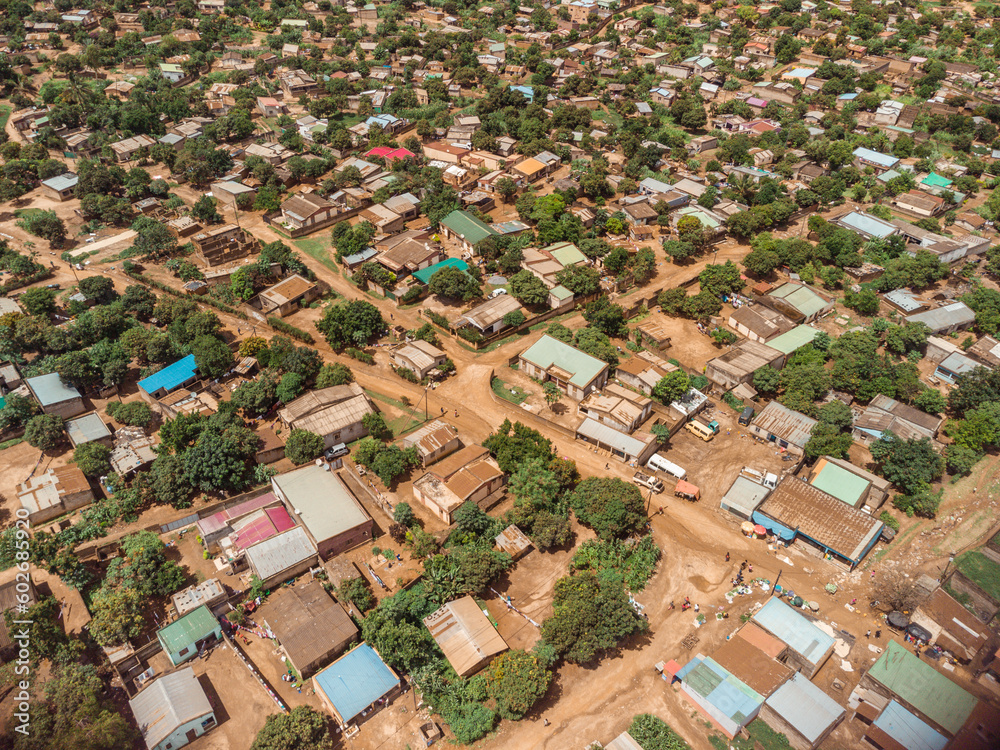 Drone shot of a small rural town in Mozambique showing unpaved dirt roads and the roofs of houses.