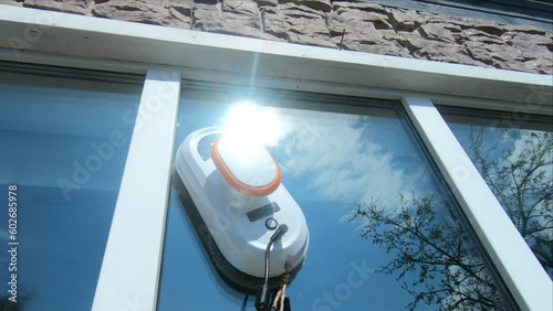 robot vacuum cleaner washes windows on a sunny day, video without filters