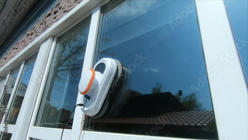 robot vacuum cleaner washes windows on a sunny day, video without filters