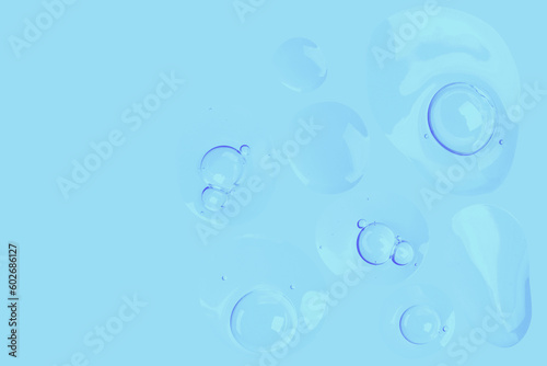 round drops of transparent gel serum on a blue background. gel with bubbles. Water droplets