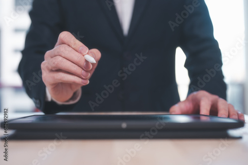 Electronic document and signature, Business and technology concept. Businessman working on digital tablet signing contract with digital pen signing ar writing on tablet screen © cherdchai