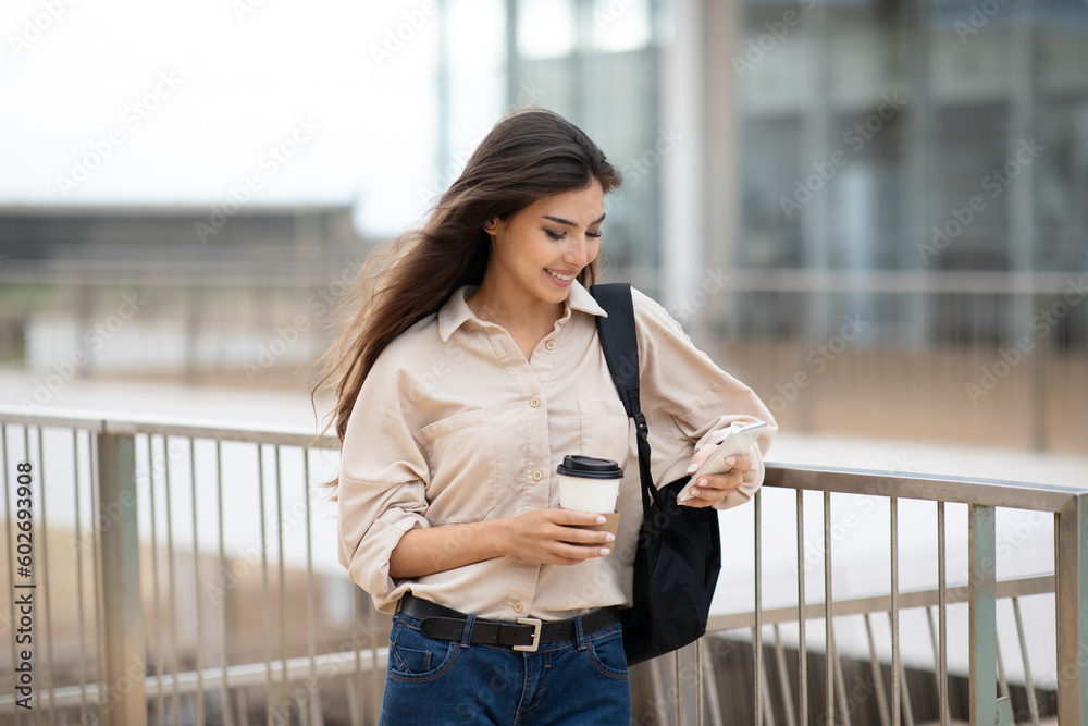 Modern communication for study. Happy young asian lady student with backpack, cup of coffee takeaway Modern communication for study. Happy young asian lady student with backpack, cup of coffee takeaway