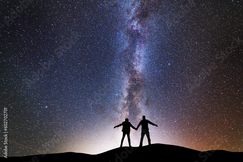 Fantasy landscape, silhouette of losers standing on the hill, on the milky way galaxy background.