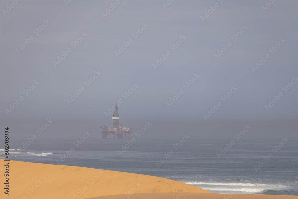 scenic view of the Namib desert with an oil rig in the background