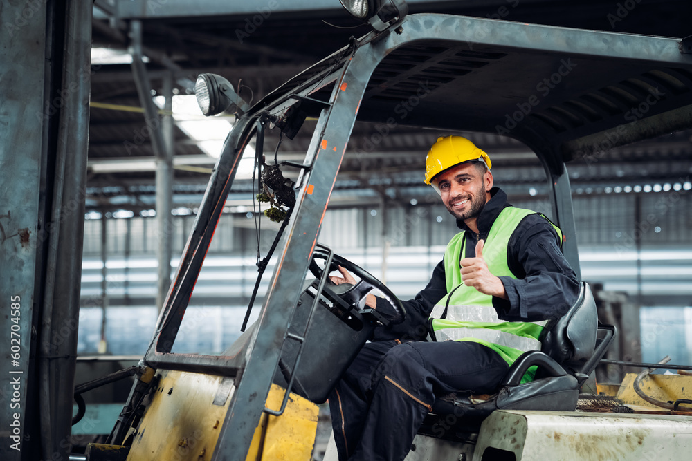 Industrial worker driving a forklift in the factory. Engineer is working and maintaining in the warehouse. Industrial worker driving a forklift in the factory. Engineer is working and maintaining in the warehouse.