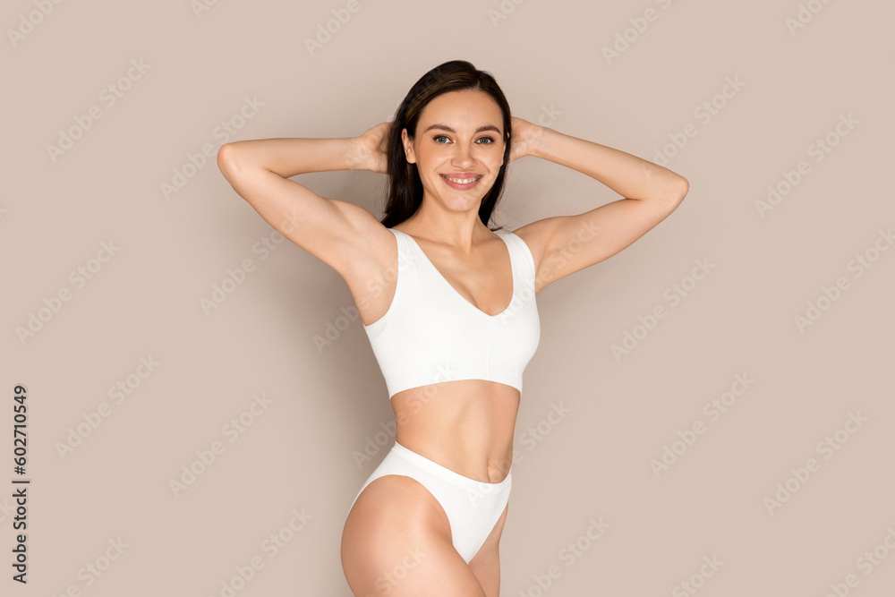Young woman showing armpit with smooth clean skin on beige Young woman showing armpit with smooth clean skin on beige