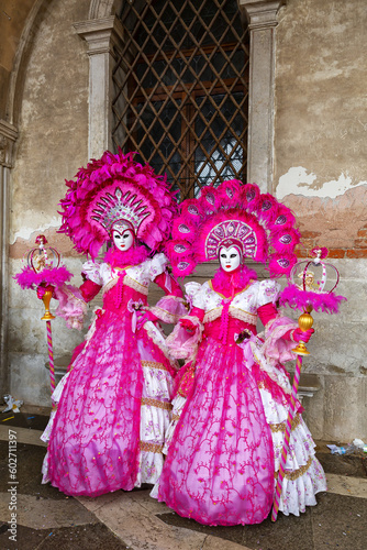 Gorgeous masquerade ladies in pink dresses at Piazza San Marco, Venice