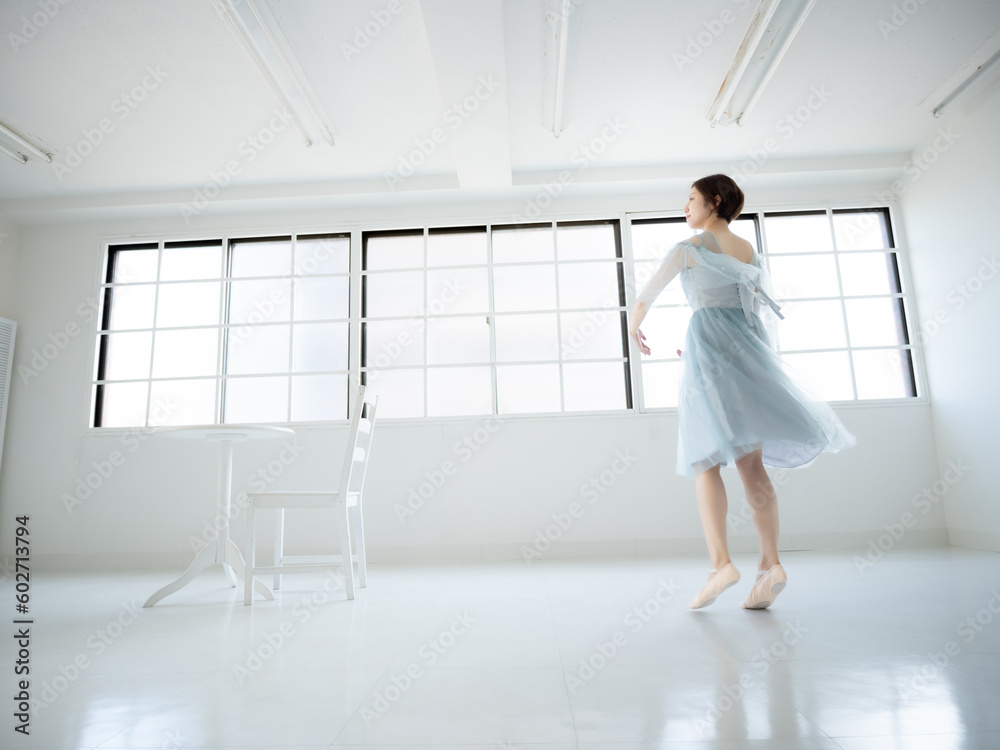 窓のある明るい室内でバレエの練習をする女性