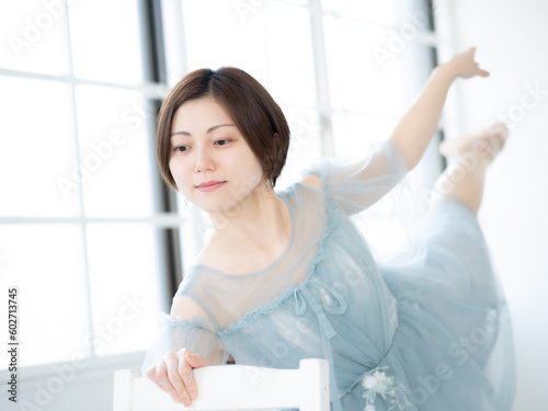 窓のある明るい室内でバレエの練習をする女性