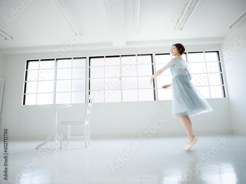 窓のある明るい室内でバレエの練習をする女性