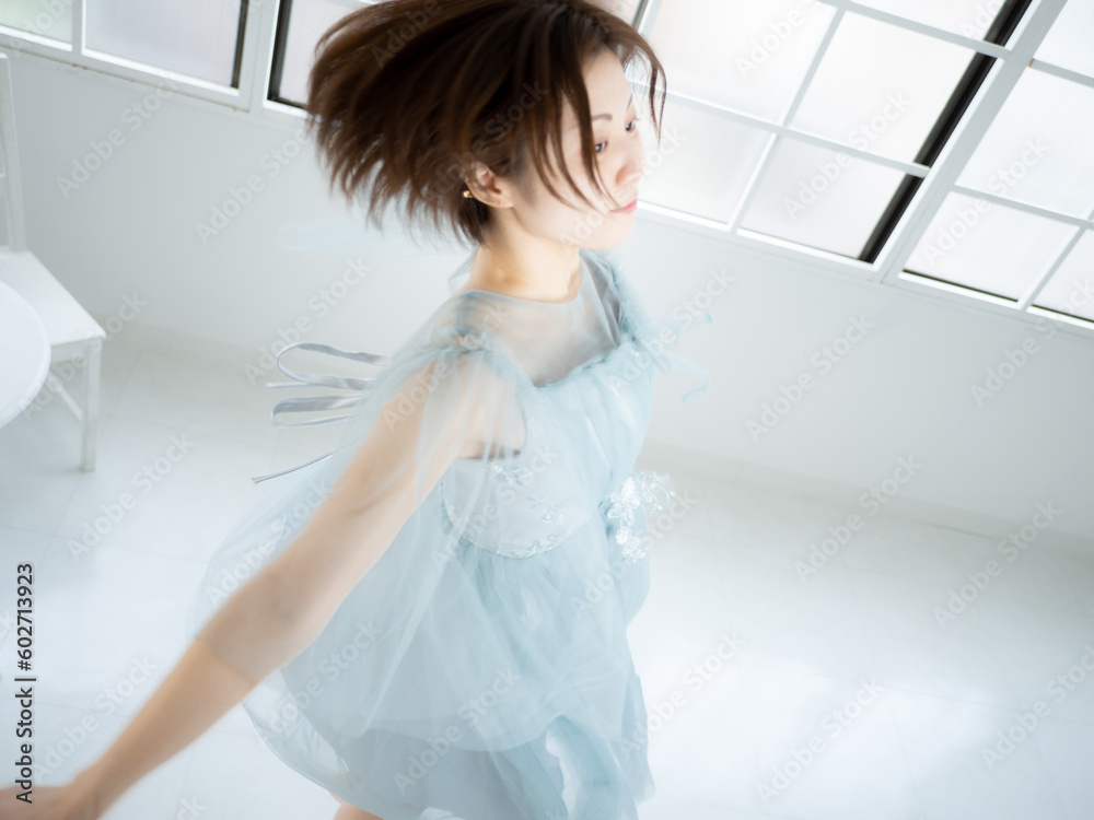 窓のある明るい室内でバレエの練習をする女性 窓のある明るい室内でバレエの練習をする女性