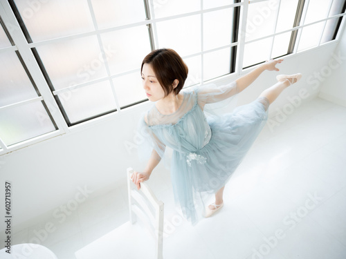 窓のある明るい室内でバレエの練習をする女性 © ODN