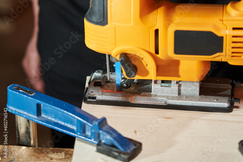 Wallpaper Mural laser light for precise sawing of a workpiece shines in front of an electric jigsaw sawing Torontodigital.ca
