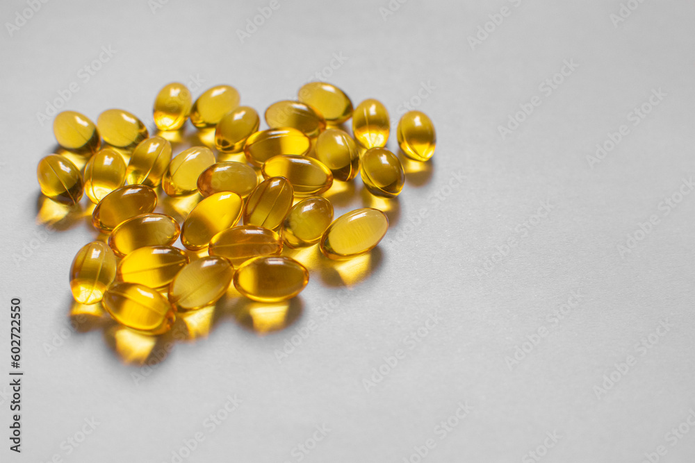yellow omega 3 capsule on white surface yellow omega 3 capsule on white surface