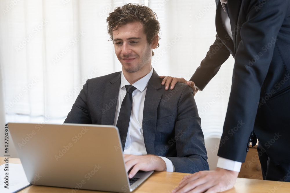 Business meeting, two caucasian, asian group businessman, male using laptop computer, notebook brainstorm analyzing data of cost plan, discussing, encourage with coworker. People working at office. Business meeting, two caucasian, asian group businessman, male using laptop computer, notebook brainstorm analyzing data of cost plan, discussing, encourage with coworker. People working at office.