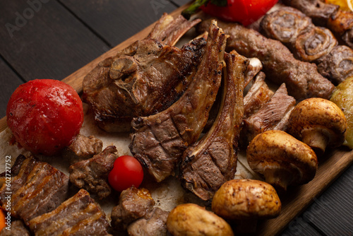 Assorted different types of halal meat made on the grill. Roast lamb, kebab, beef, mushrooms, tomatoes, onions and peppers. Close-up.