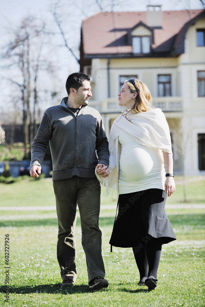 Fototapeta premium happy young married family couple outdoor in nature have fun and waiting baby and representing young family growth and pregnancy concept