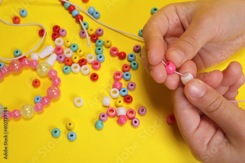 Φωτογραφία Closeup of making decorative bracelet of colored beads