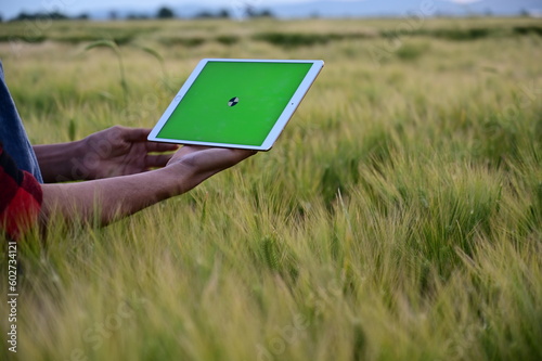 Man using tablet at field. Future of Agriculture: The New Face of Efficient Farming Managed by Tablets.