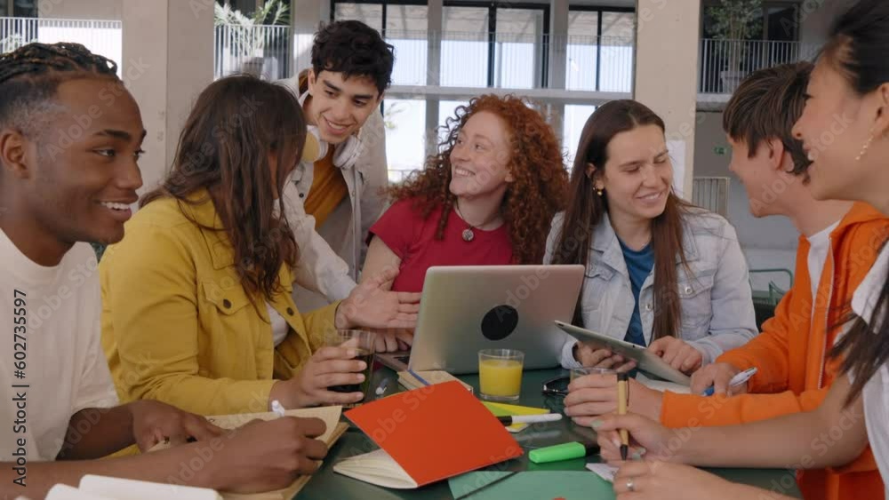 Smiling college classmates using laptops in campus cafeteria. Group of ...