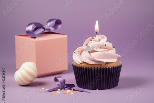 Tasty cupcake with birthday candle and gift box on lilac background