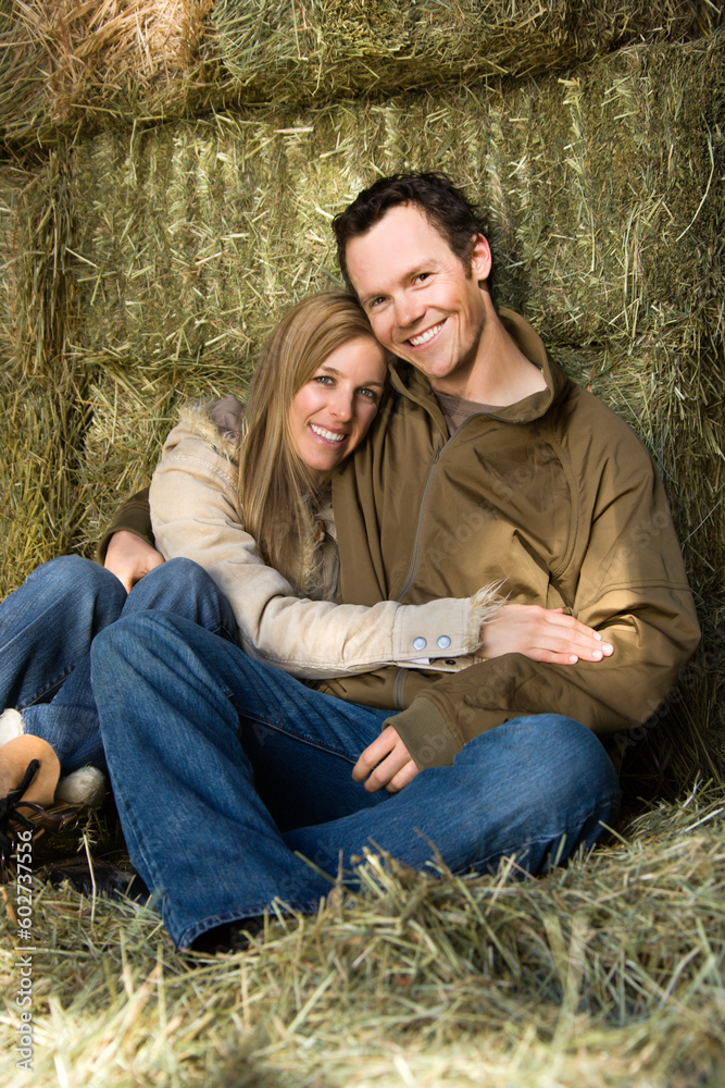 Obraz premium Mid-adult Caucasian couple hugging and looking at viewer.