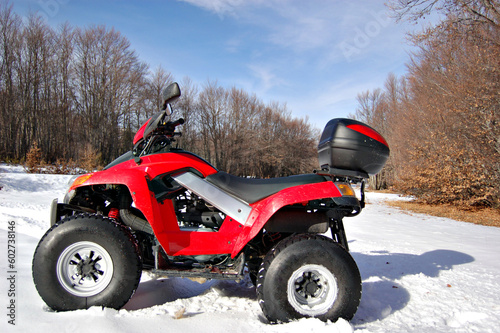 red quad bike in snow mountain scenery