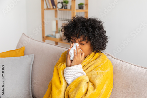 Принти на полотні Unhappy sick young african american woman with cold sitting on sofa at home
